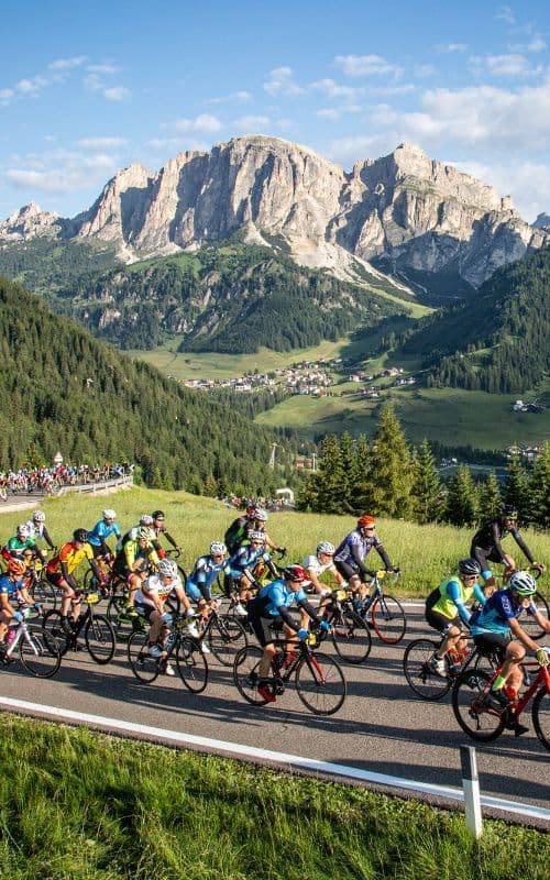 hundreds of cyclists riding up a snaking mountain path